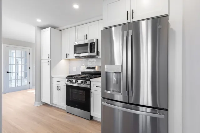 a kitchen with stainless steel appliances a refrigerator stove and microwave