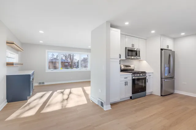 a kitchen with a refrigerator and a stove top oven