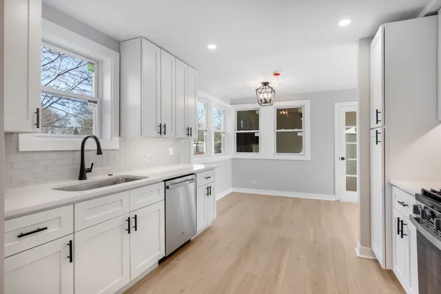 a large kitchen with stainless steel appliances granite countertop a lot of counter space and wooden floors