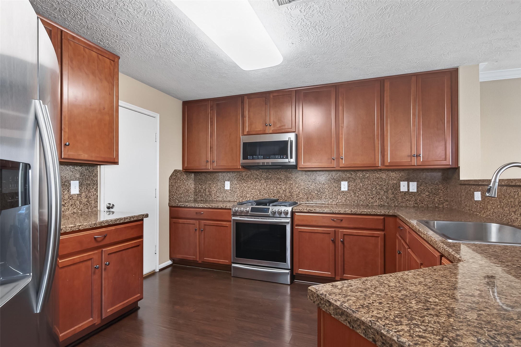 18110 Rexine Lane Cypress, TX 77433 - Photo 15 of 50 a kitchen with stainless steel appliances granite countertop a sink stove and refrigerator