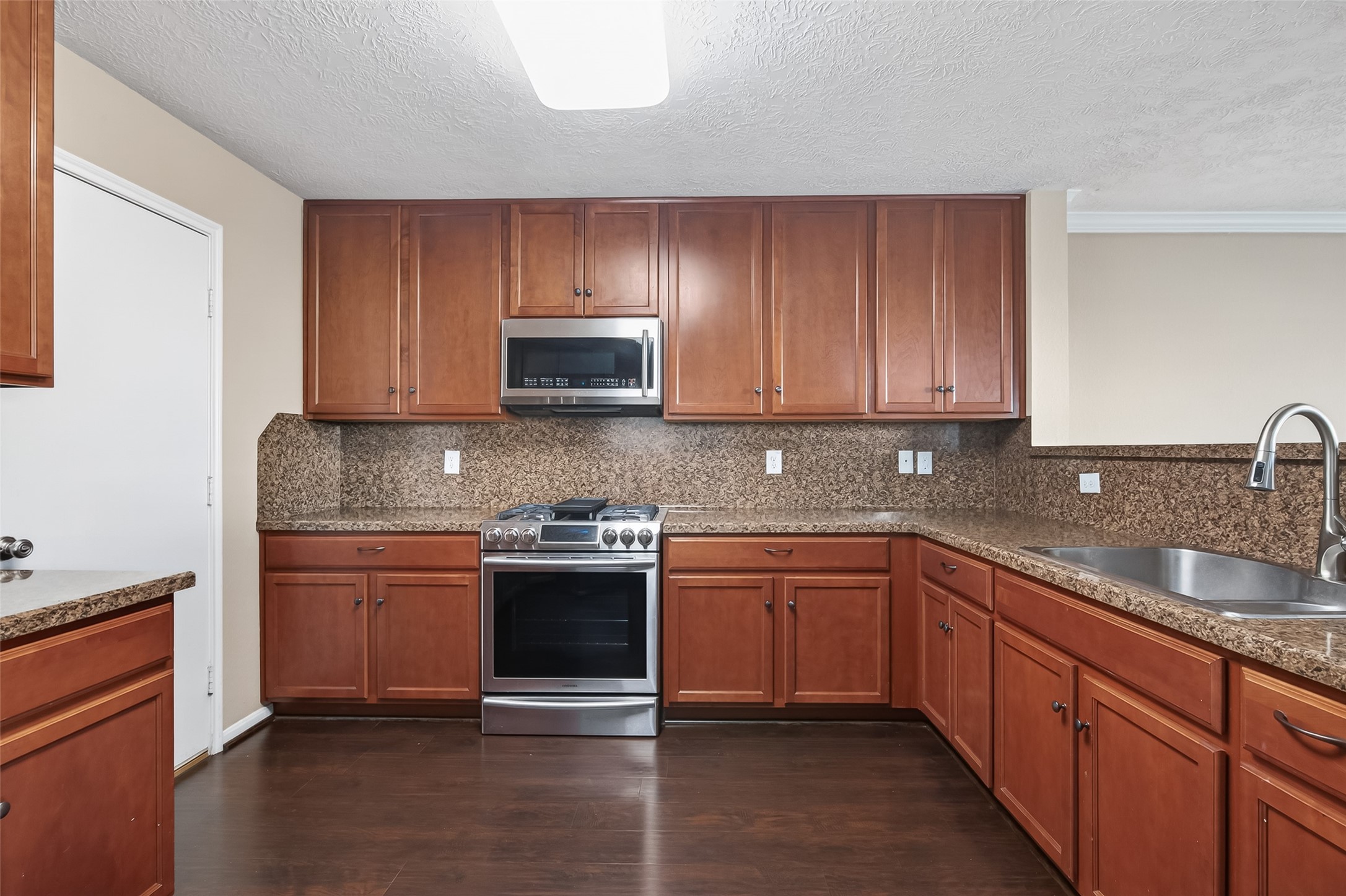 18110 Rexine Lane Cypress, TX 77433 - Photo 16 of 50 a kitchen with stainless steel appliances granite countertop a sink stove and microwave