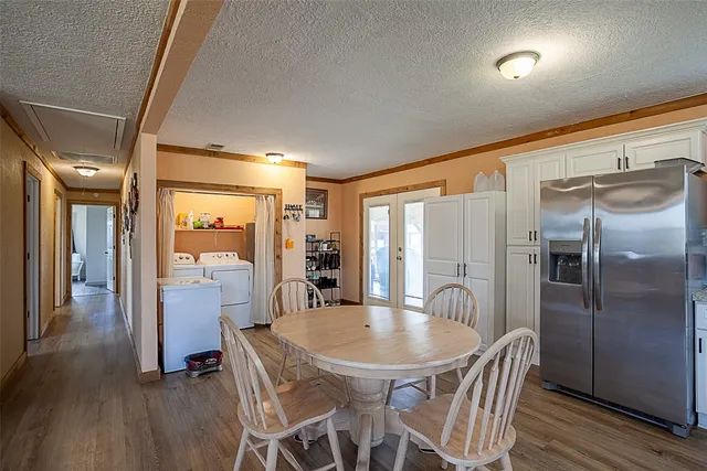 a kitchen with dining table and stainless steel appliances