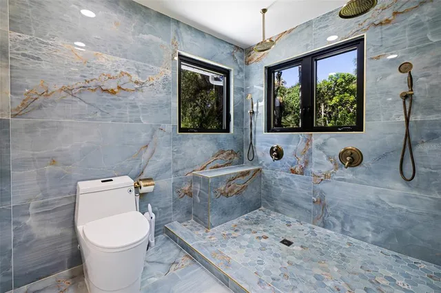 a bedroom with a bed a chandelier and dresser