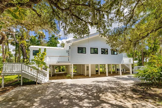 a large white kitchen with cabinets a sink and appliances