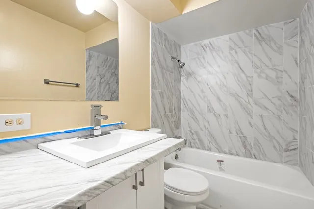 a bathroom with a sink a toilet and shower