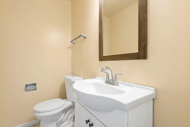 a bathroom with a sink a toilet and mirror