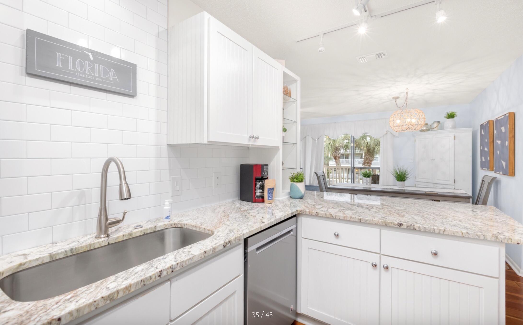 3799 East County Highway 30A, Unit E12 Santa Rosa Beach, FL 32459 - Photo 12 of 34 a kitchen with granite countertop a sink stainless steel appliances and cabinets