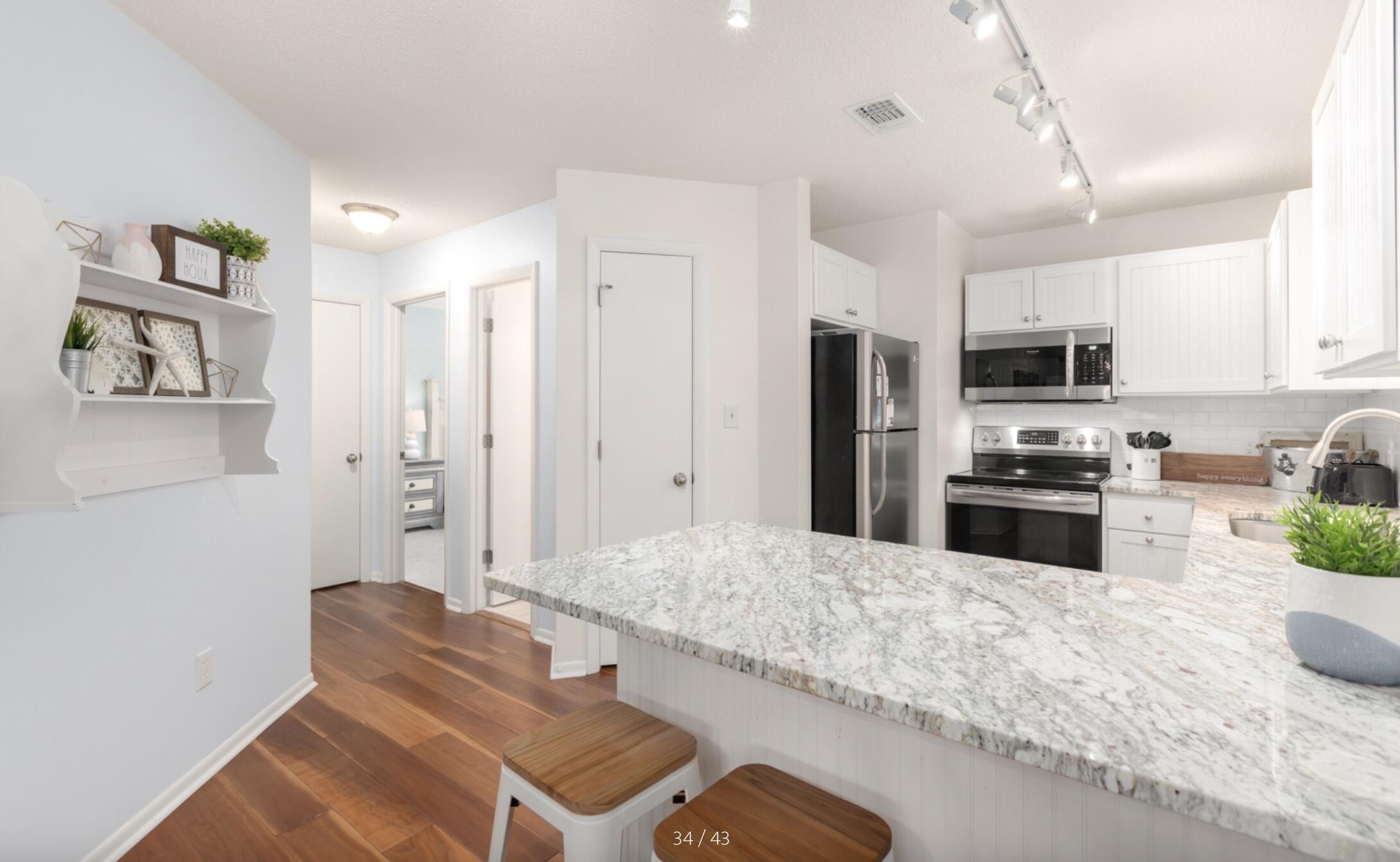 3799 East County Highway 30A, Unit E12 Santa Rosa Beach, FL 32459 - Photo 13 of 34 a kitchen with granite countertop a refrigerator stove microwave and sink