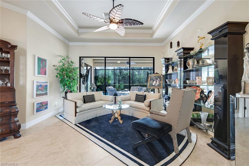 11050 Longwing Drive Fort Myers, FL 33912 - Photo 1 of 43 Living room featuring a raised ceiling, ornamental molding, light tile patterned flooring with sliding doors to covered lanai and pool