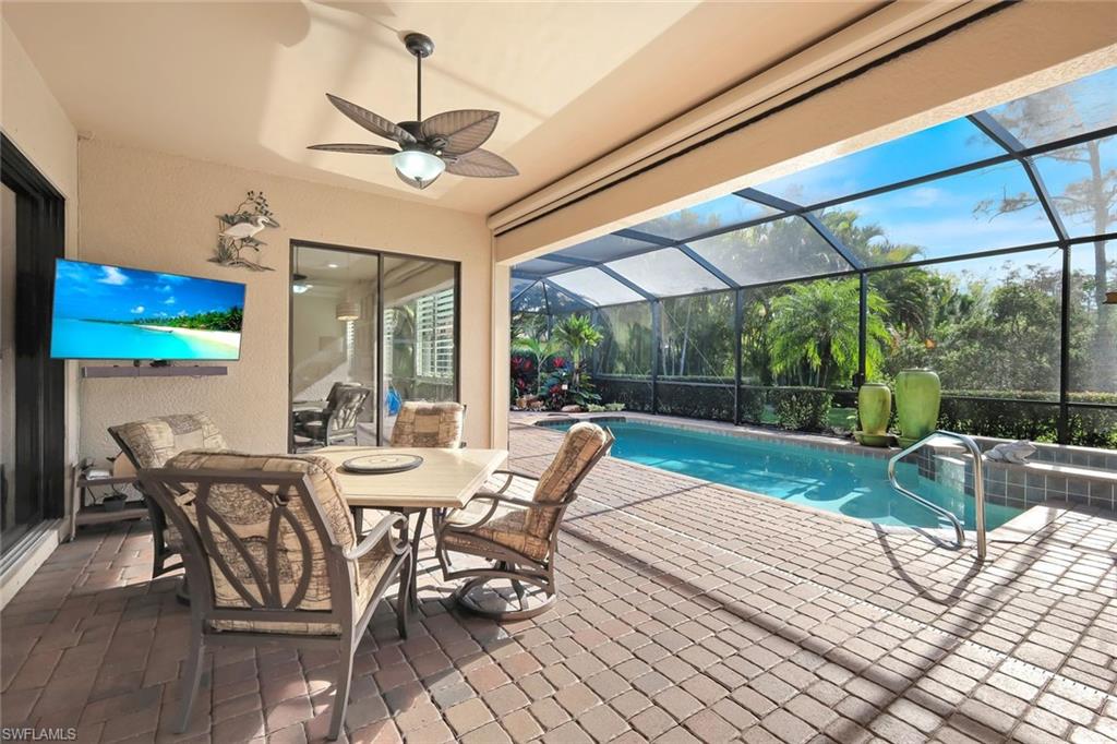 11050 Longwing Drive Fort Myers, FL 33912 - Photo 24 of 43 View of pool with a patio area, a sunroom, glass enclosure, a pool with connected hot tub, and outdoor dining space