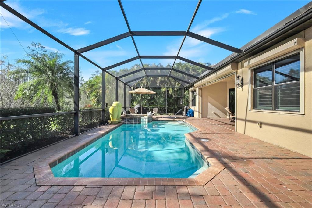 11050 Longwing Drive Fort Myers, FL 33912 - Photo 26 of 43 View of swimming pool with a sunroom, a lanai, a pool with connected hot tub, and a patio