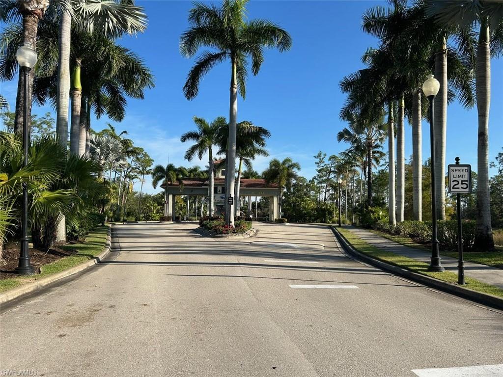 11050 Longwing Drive Fort Myers, FL 33912 - Photo 34 of 43 View of asphalt road with curbs, street lighting, traffic signs, and sidewalks