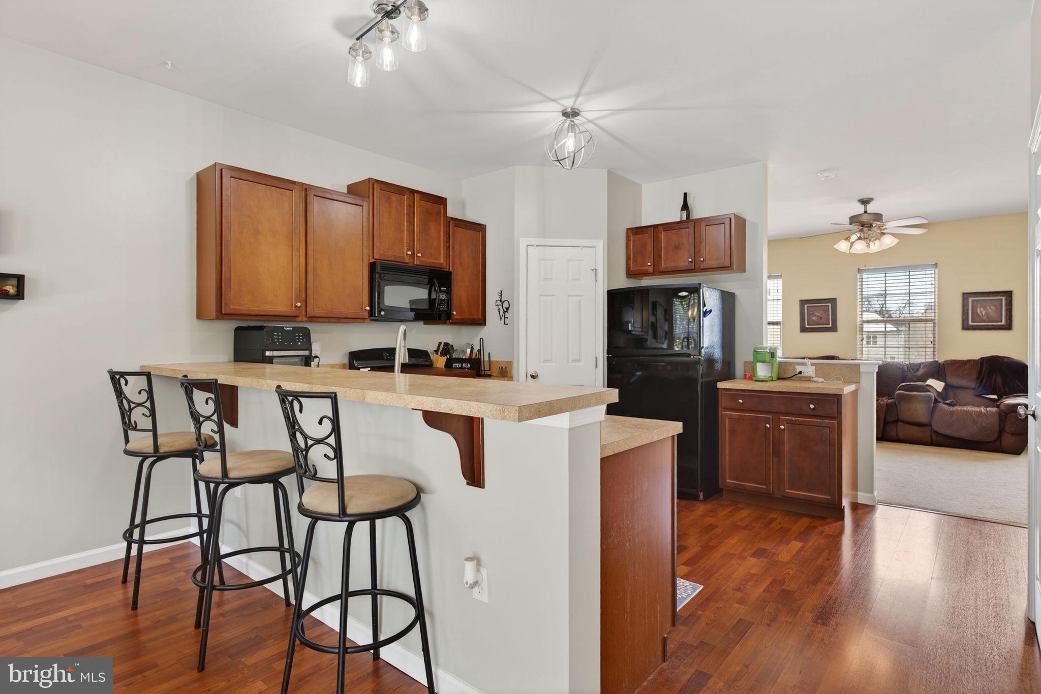 2436 Schultz Way, Unit 19 York, PA 17402 - Photo 9 of 30 a kitchen with stainless steel appliances granite countertop a stove top oven a sink dishwasher a dining table and chairs with wooden floor