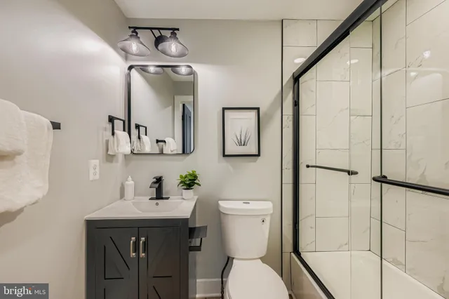 a bathroom with a toilet a sink and mirror