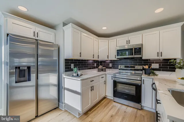 a kitchen with white cabinets and stainless steel appliances