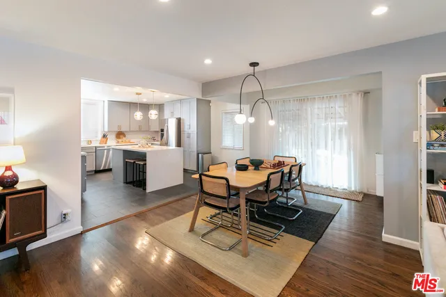 a kitchen with kitchen island a sink stainless steel appliances cabinets and a window
