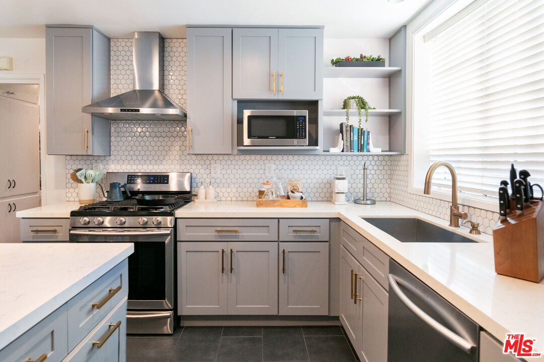 2415 8th Avenue Los Angeles, CA 90018 - Photo 14 of 55 a kitchen with granite countertop a sink stove and cabinets