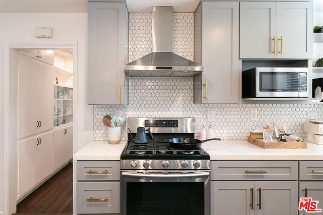 a kitchen with stainless steel appliances granite countertop a stove and a microwave