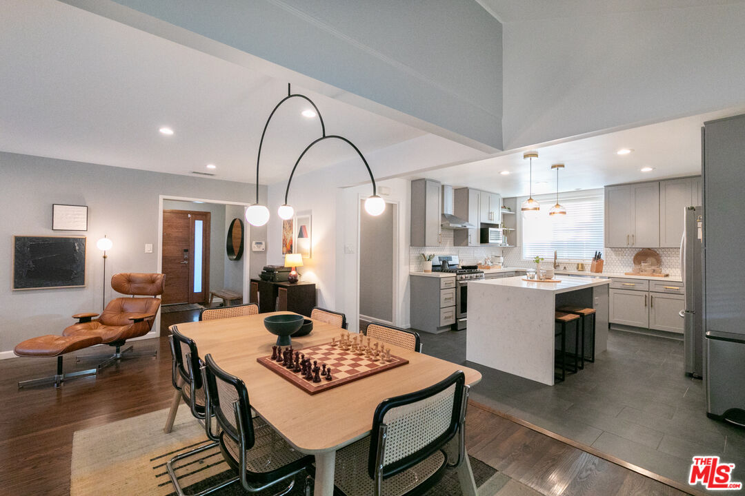 2415 8th Avenue Los Angeles, CA 90018 - Photo 27 of 55 a living room with stainless steel appliances kitchen island granite countertop a dining table and chairs with wooden floor