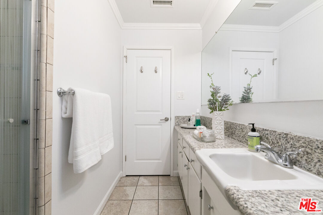 2415 8th Avenue Los Angeles, CA 90018 - Photo 36 of 55 a bathroom with a granite countertop sink and a mirror