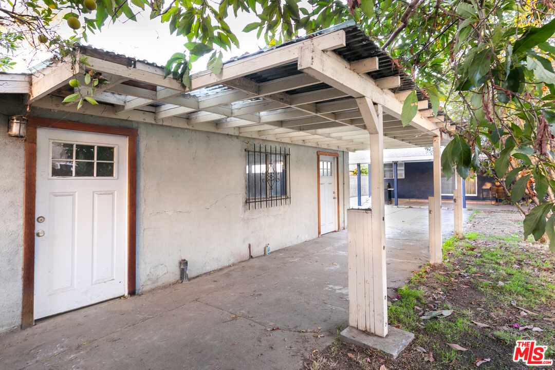 2415 8th Avenue Los Angeles, CA 90018 - Photo 50 of 55 a view of a white house with a small yard and a large tree