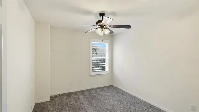 a view of a hallway with a window and a ceiling fan