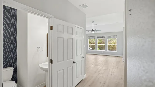 a view of a hallway with wooden floor and windows