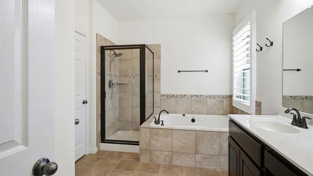 a bathroom with a tub sink and mirror