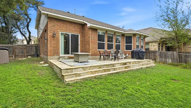 a view of a house with backyard and sitting area