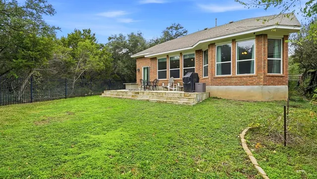 a view of a house with a yard and sitting area
