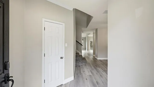 a view of a hallway with wooden floor