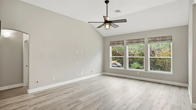 a view of room with window ceiling fan and hardwood floor