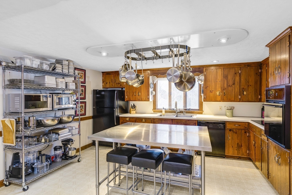245 Newbury Road Rowley, MA 01969 - Photo 13 of 40 a kitchen with stainless steel appliances a sink and a refrigerator