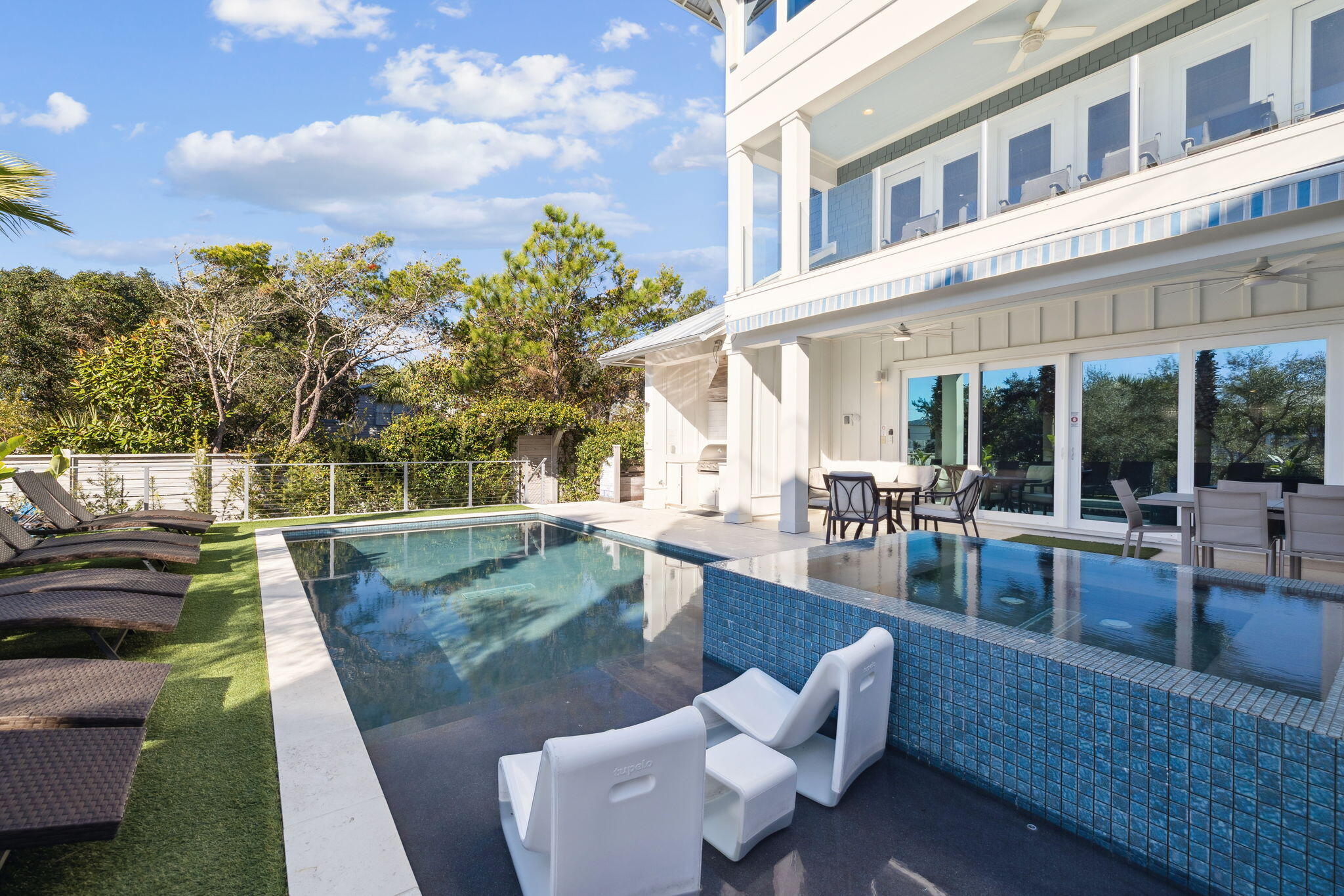 230 Blue Lake Road Santa Rosa Beach, FL 32459 - Photo 45 of 110 a view of a patio with couches and table potted plants and palm tree