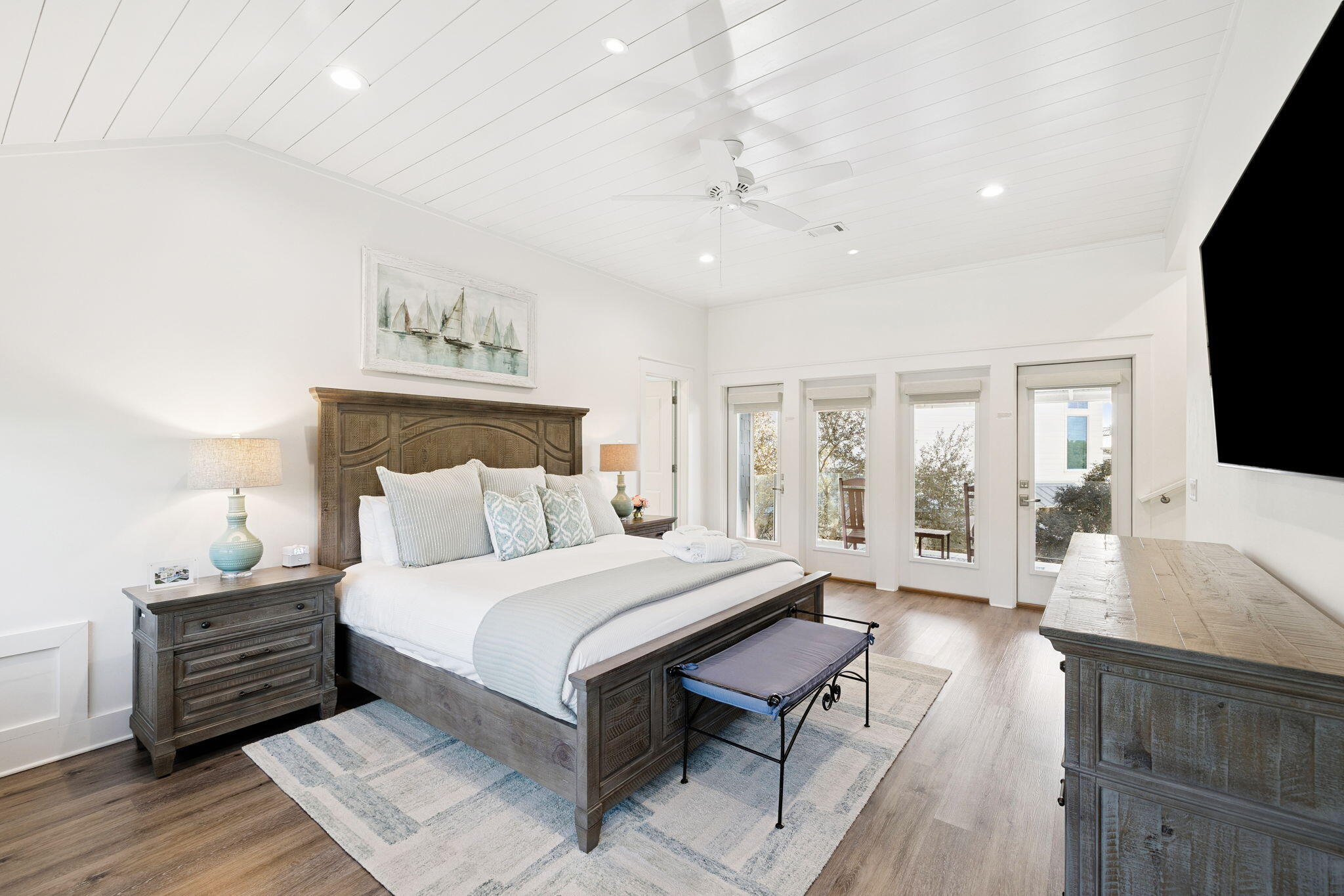 230 Blue Lake Road Santa Rosa Beach, FL 32459 - Photo 65 of 110 a spacious bedroom with a large bed a chandelier and windows
