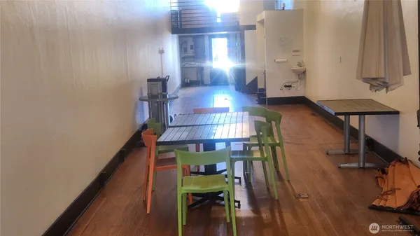 a view of a hallway with furniture and wooden floor