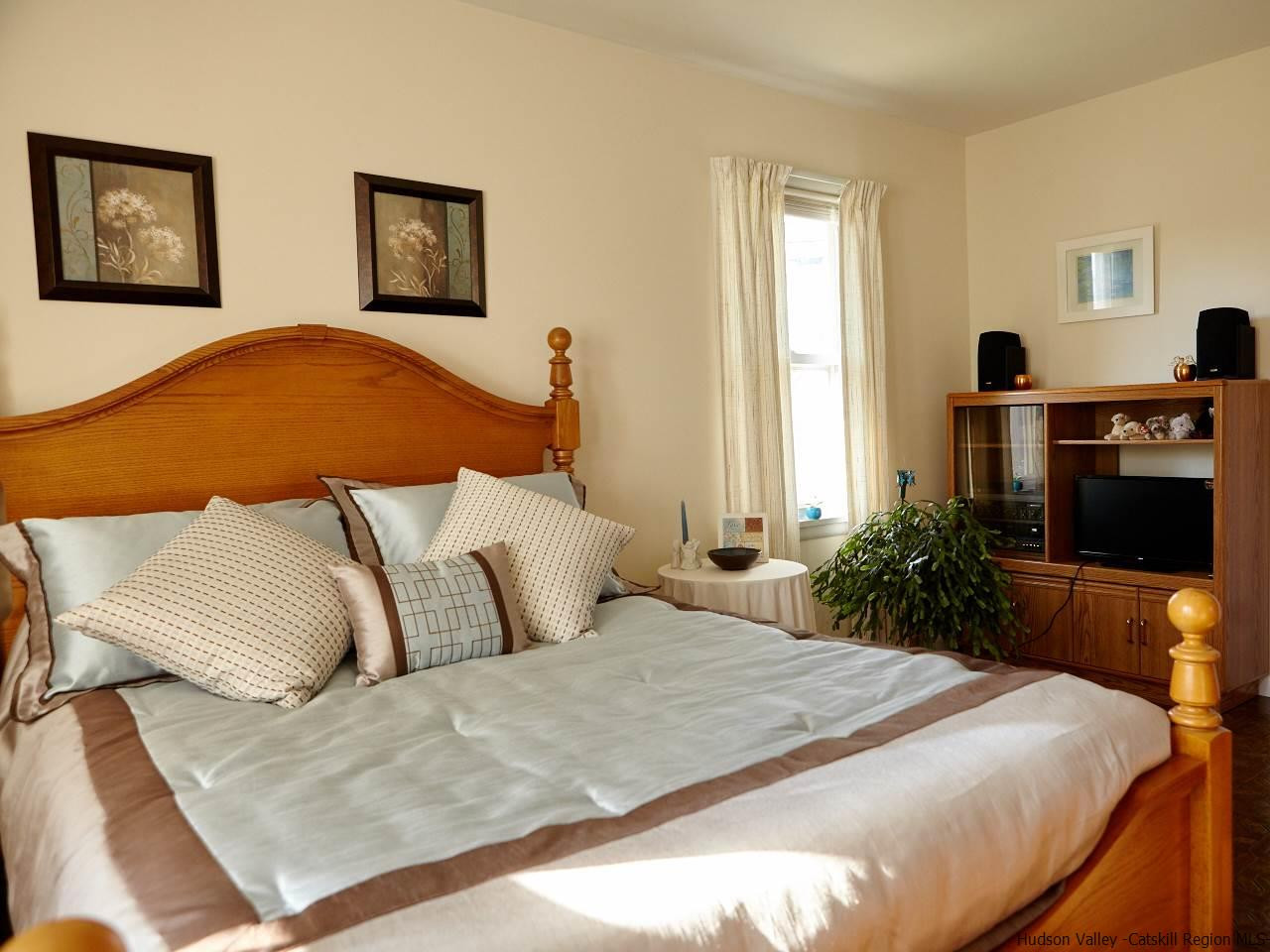 104 South Riverside Road Highland, NY 12528 - Photo 12 of 28 a bedroom with a bed and a flat screen tv