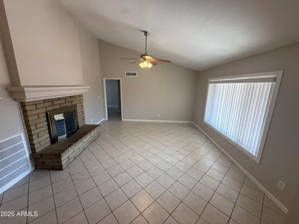 an empty room with windows and fireplace