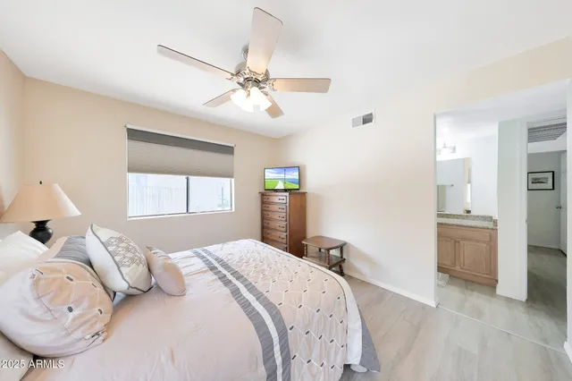a bedroom with a large bed and a chandelier