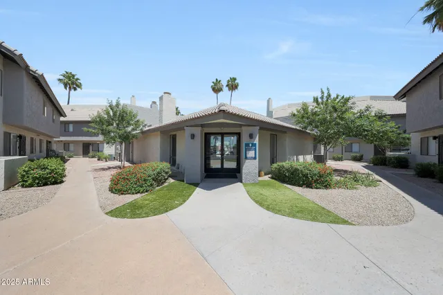 a front view of a house with a yard and potted plants