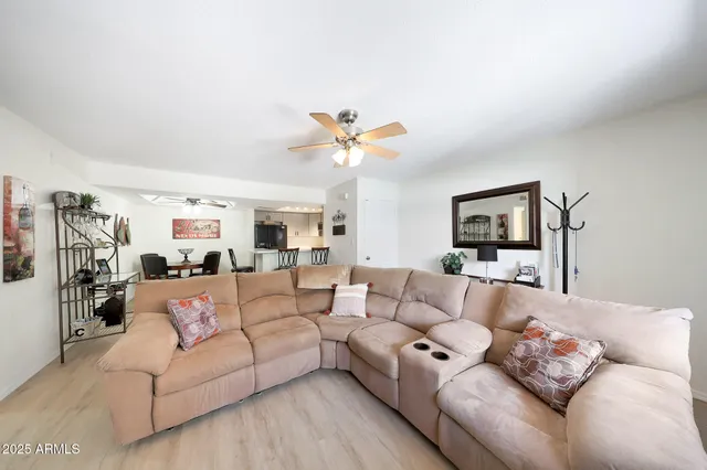 a living room with furniture and a ceiling fan