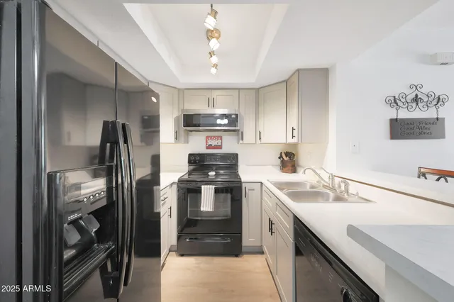 a kitchen with kitchen island a sink appliances and cabinets