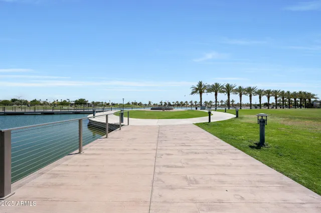a view of a lake with a yard and large trees