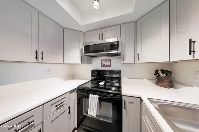 a kitchen with white cabinets stainless steel appliances and sink