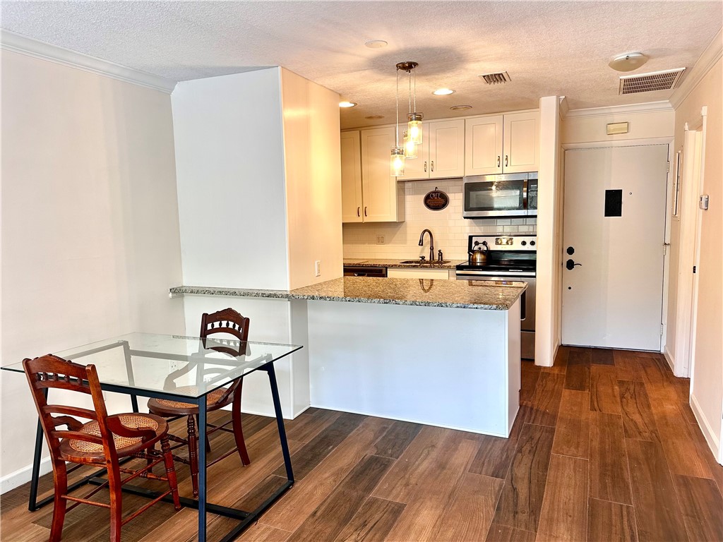 1815 Robalo Drive, Unit C201 Vero Beach, FL 32960 - Photo 7 of 31 a kitchen with stainless steel appliances a stove a sink a refrigerator and wooden floor