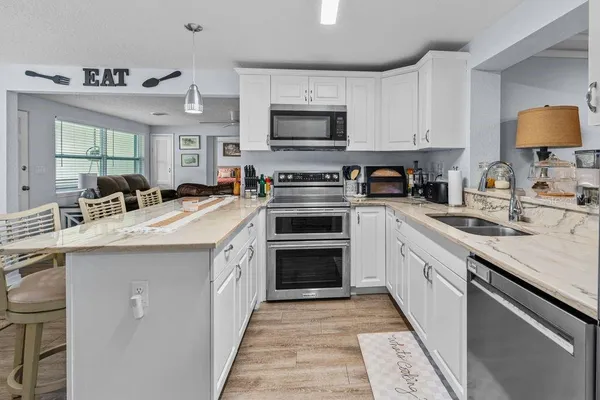 a kitchen with a sink stove and microwave