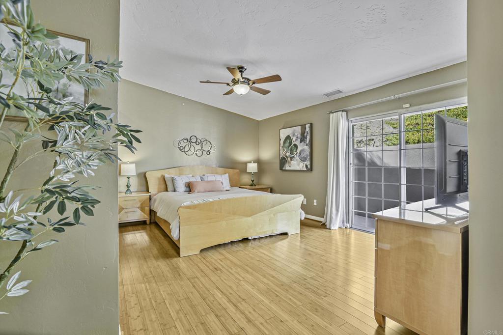 1460 Orpheus Avenue Encinitas, CA 92024 - Photo 16 of 24 a spacious bedroom with a large bed and a chandelier
