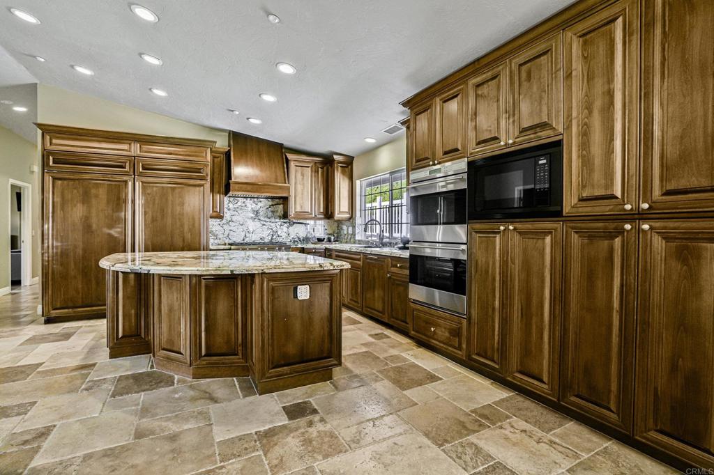 1460 Orpheus Avenue Encinitas, CA 92024 - Photo 4 of 24 a kitchen with stainless steel appliances granite countertop a refrigerator a stove top oven and sink