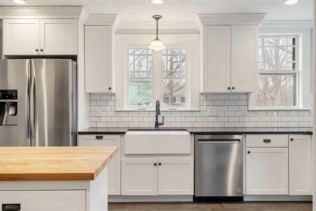 a kitchen with kitchen island granite countertop a sink cabinets and stainless steel appliances