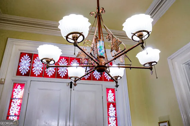 a living room with furniture a chandelier and a flat screen tv
